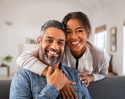 two older ucla alumni embrace and flash warm smiles